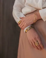 Pulsera tipo esclava abierta con diseño rústico y acabado irregular, fabricada en bronce y alpaca.