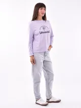 Remera de manga larga color beige, con cuello redondo y estampado frontal que dice "Magic is something you make" en color lila.