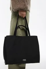 Bolso shopper de gran capacidad confeccionado en nylon color marrón, con estructura blanda, doble asa de mano y logo metálico de la marca en la parte frontal. Incluye cierre con mosquetón y bolsillo interior.