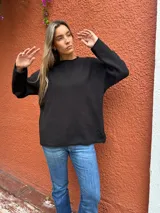 Sweater de tejido de punto color negro, con cuello redondo, mangas largas y corte holgado.