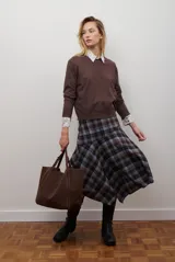 Falda midi de corte asimétrico con estampado de cuadros en tonos azules, grises y marrones. Presenta un diseño con vuelo y caída fluida.