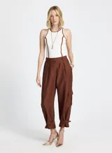 Musculosa blanca de punto con corte recto, cuello redondo, sisas amplias y vivo terracota en cuello y sisas.