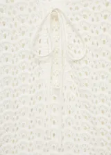 Vestido largo de crochet color blanco, con escote en V con lazo ajustable y mangas largas.