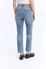 Jean straight crop de tiro alto, con piernas rectas y largo por encima de los tobillos. Presenta terminación desflecada y diseño clásico con bolsillos.