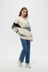 Sweater de tejido de punto con diseño geométrico color block en tonos beige, gris y negro, de corte holgado, cuello redondo y manga larga.