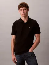 Chomba negra de piqué de algodón, corte clásico, cuello tradicional y tapeta de botones. Logo de Calvin Klein bordado en el pecho.