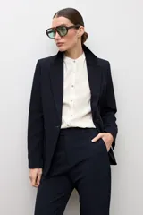 Blazer clásico color negro de corte entallado, con solapa de muesca, cierre de un botón frontal y bolsillos de ojal en los laterales.