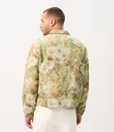 Campera trucker de Marfinno para hombre, con diseño de estampado floral en tejido jacquard texturizado de tonos verdes y beige. Presenta cuello camisero, cierre frontal de botones metálicos y bolsillos en el pecho.