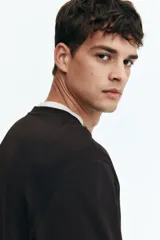 Remera de manga larga color marrón oscuro, con cuello redondo acanalado y corte recto.