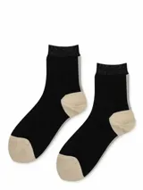 Par de calcetines negros con puntera y talón color beige, puño superior con hilo brillante y raya vertical en la parte posterior.