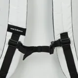 Mochila New Balance unisex de color blanco con logo negro, cierre superior con cordón y tapa con hebilla, bolsillo frontal con tapa y bolsillos laterales de malla.