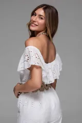 Mono largo blanco de broderie con escote off-shoulder con volados y cinturón marrón con hebilla circular.