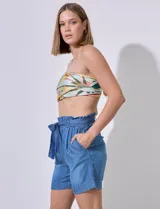 Short blanco de tencel, con pretina ancha elastizada y lazo de ajuste. Presenta bolsillos verticales en la parte delantera.