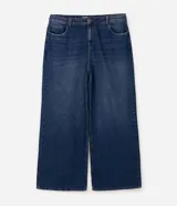 Pantalón wide leg de jean color azul oscuro con diseño de tiro alto, pernera amplia y recta, bolsillos estilo five pockets y cierre frontal con botón y cremallera.