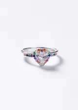 Anillo de plata 925 con diseño de corazón central compuesto por una zirconia transparente, rodeado por pequeñas piedras multicolor. El cuerpo del anillo también presenta incrustaciones de piedras en tonos variados a lo largo de la banda.
