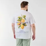 Camiseta blanca de manga corta, con cuello redondo y estampado pequeño en el pecho con el texto "Costa Limone Naturale Selezionato" en azul.