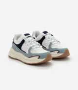 Championes estilo jogging con diseño de recortes contrastantes en tonos blanco, azul y gris. Presenta una parte superior de mesh respirable con sobreposiciones de poliuretano, forro suave y suela robusta de color crema con base marrón.