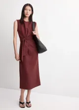 Vestido midi color bordó con cuello redondo, sin mangas y corte recto, con detalle de nudo y lazo ajustable en la cintura.