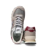 Championes urbanos New Balance modelo 574, color gris con detalles en bordó y blanco. Confeccionados en gamuza y malla, con el logo N característico en los laterales y entresuela con tecnología ENCAP.