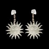 Par de aros colgantes plateados con forma de sol y rostro.