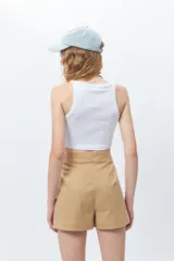 Top corto de tejido acanalado color marrón, con cuello redondo y corte de sisa tipo nadador.