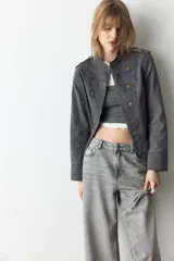 Jean de cinco bolsillos en denim de algodón rígido, de corte holgado estilo baggy, con piernas rectas y tiro alto. Presenta efecto deslavado y cierre con botón y cremallera.
