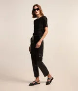 Blusa de viscosa color negro con estampado de rayas horizontales plateadas, cuello redondo y mangas cortas.