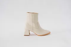 Botas cortas de cuero color crema, con cierre lateral y taco cuadrado. Forro, capellada y plantilla 100% cuero.