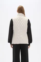 Chaleco acolchado de diseño capitoneado en color verde militar, con cuello alto, cierre frontal con botones a presión y bolsillos laterales con solapa y detalles en contraste.