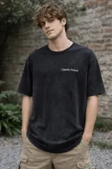 Remera de algodón premium con efecto lavado, manga corta y cuello redondo. Presenta un estampado gráfico en la espalda con el texto 'Cherry Season' y un diseño de cerezas pixeladas.