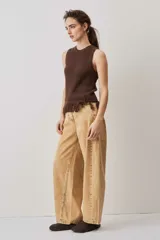 Blusa tejida sin mangas en color marrón chocolate, con textura acanalada, cuello redondo y detalle de flecos en el ruedo.