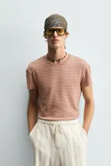 Camiseta de algodón con cuello redondo y manga corta, confeccionada en tejido jacquard a rayas horizontales en tonos terracota y beige.