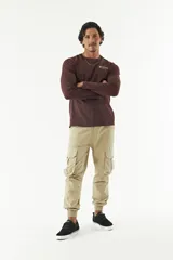 Pantalón cargo color beige con puños ajustados, bolsillos laterales con fuelle y pasacinto.