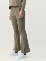 Calza pantalón color verde oliva, tipo flare, de tejido Peach_T con tacto de piel de melocotón. Tiene bajo acampanado ligero con aberturas, costuras decorativas y bolsillos laterales.