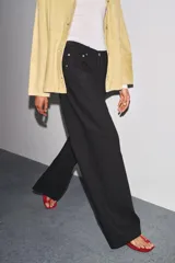 Jeans de tiro bajo, pierna ancha y largo completo, color negro. Presenta cinco bolsillos y cierre frontal con cremallera y botón metálico.