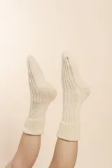 Medias tejidas a máquina en punto elástico, color crudo. Confeccionadas en lana fina sin teñir.