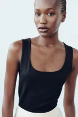 Camiseta blanca ajustada de poliamida con tirantes anchos y escote redondo.