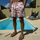 Short de baño negro con estampado de rodajas de naranja, cintura elástica con cordón ajustable y logo circular en el ruedo.
