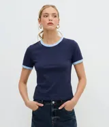 Remera tipo baby tee azul marino de manga corta, con ribetes en color celeste en el cuello redondo y los puños.