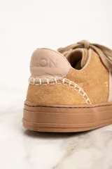 Zapatillas bajas color beige con detalles en cuero color crema.