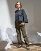 Pantalón verde militar tornasolado de algodón brillante, corte a la cintura y piernas rectas con textura de tableado central.