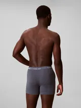 Pack de tres bóxers Calvin Klein de algodón elástico, con cintura elástica distintiva de la marca. Incluye un modelo en color negro, uno en gris y uno en rojo.