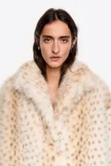 Chaquetón de corte globo en pelo sintético con estampado animal print sutil. Presenta un maxi cuello camisero, cierre frontal oculto y mangas largas rectas con bolsillos laterales integrados.
