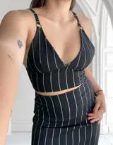 Top negro con breteles finos regulables y aro metálico en la unión de los breteles y la copa.