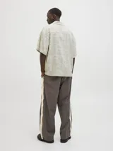 Camisa de manga corta con cuello resort y corte amplio. Confeccionada en tejido plano con estampado geométrico y botánico en tonos neutros.