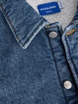 Camisa de denim azul de manga larga con fit oversize, cuello camisero, puños abotonados y bolsillo en el pecho. Presenta un lavado rinse que aporta un acabado limpio y suave.
