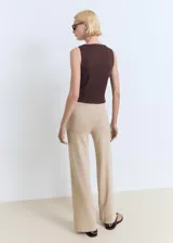Pantalón de punto fino en color beige, con diseño recto y largo. Cuenta con cintura elástica con cordón ajustable.