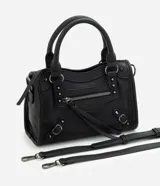 Cartera satchel Satinato de color negro, confeccionada en poliuretano. Cuenta con asas de mano fijas, correa larga removible, bolsillos frontales con cierre, tachas metálicas decorativas y tiras colgantes.
