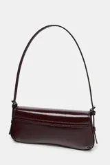 Bolso de hombro con solapa y acabado efecto acharolado. Cuenta con asa ajustable y cierre mediante imán.
