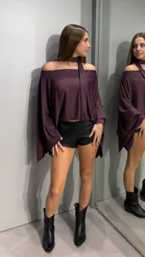 Top de corte capa con escote hombros descubiertos y detalle de cuello tipo choker integrado con tira larga. Confeccionado en tejido con acabado brillante y textura sutil.